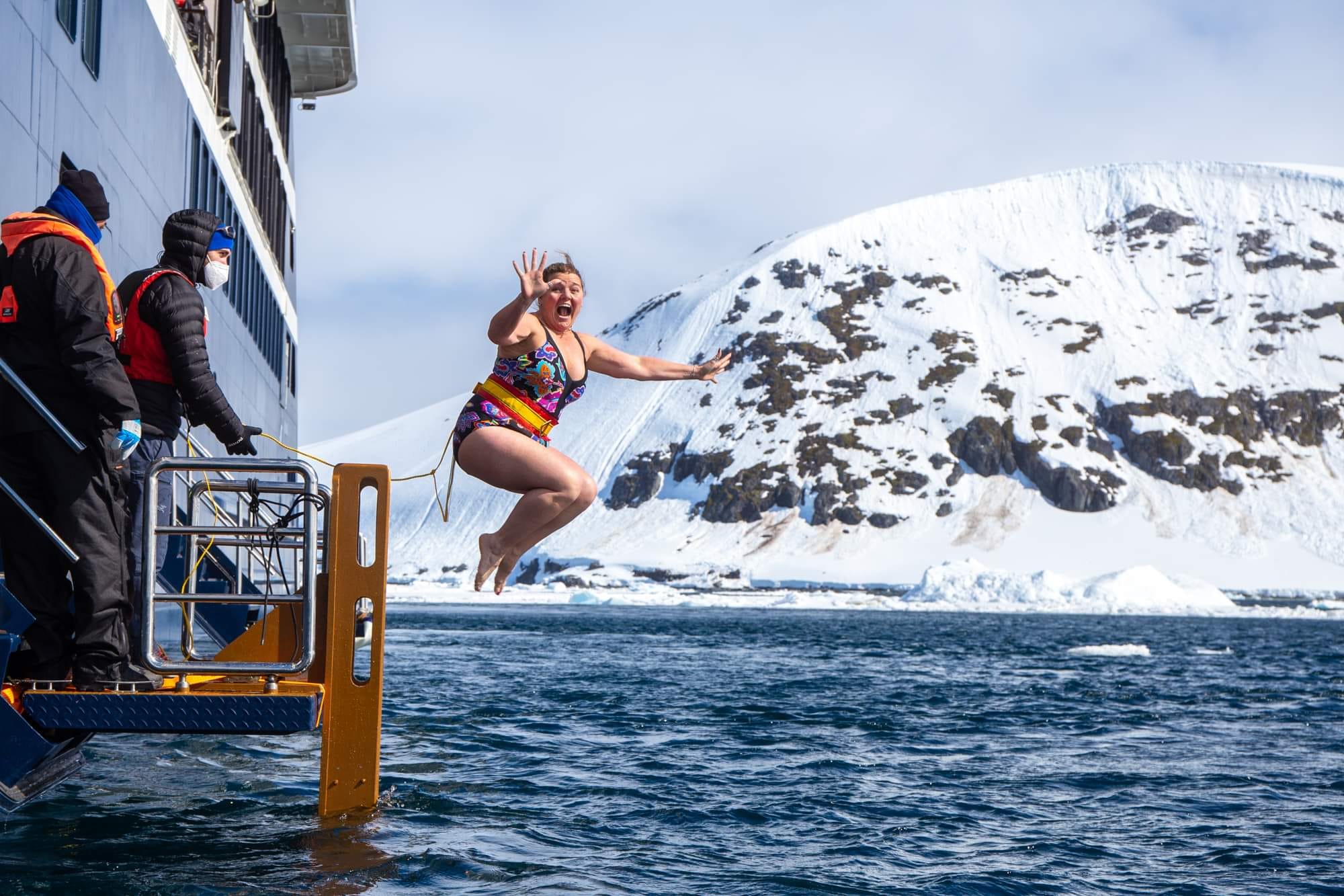 Tiffany Watt leaping from the expedition ship into the water during the Antarctic polar plunge