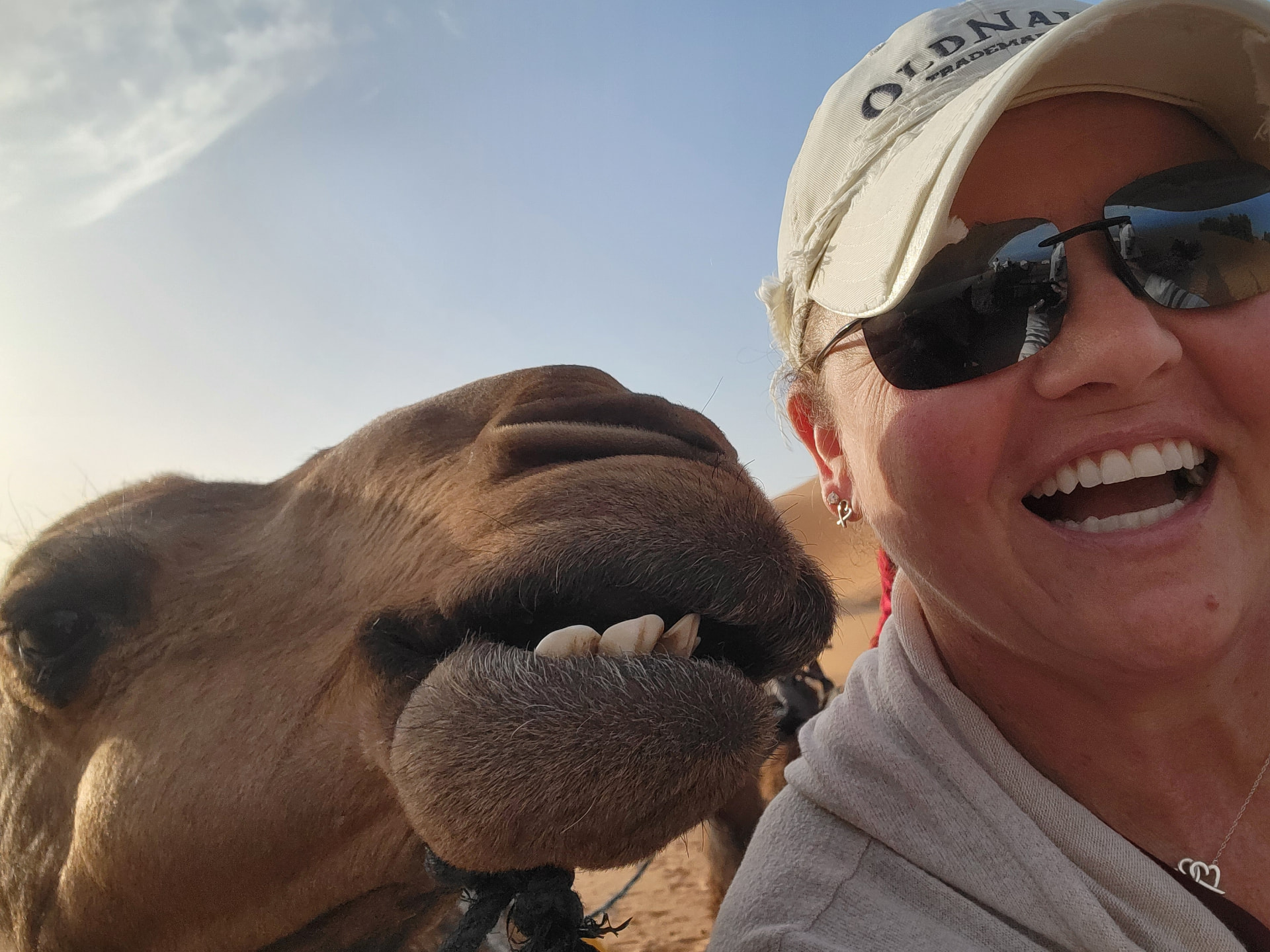 Tiffany Watt smiling beside a camel in the Sahara Desert